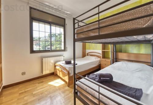 a bedroom with two bunk beds and a window at Costacabana - Villa Paris in Lloret de Mar