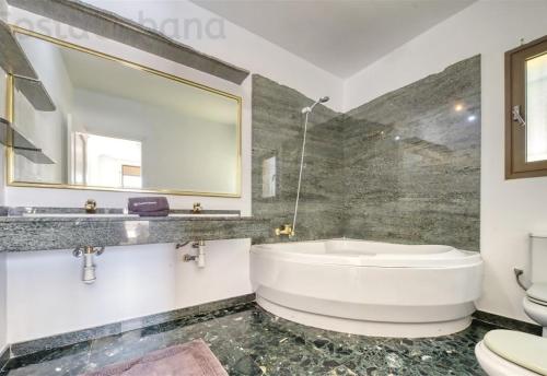 a bathroom with a tub and a toilet and a mirror at Costacabana - Villa Paris in Lloret de Mar