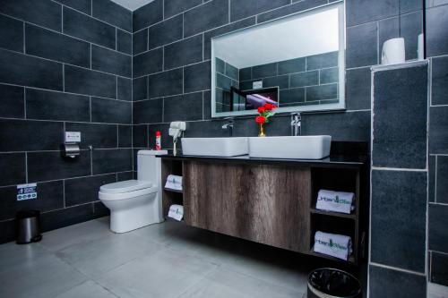 a bathroom with a sink and a toilet and a mirror at Urban Bliss Hotel in Kabwe