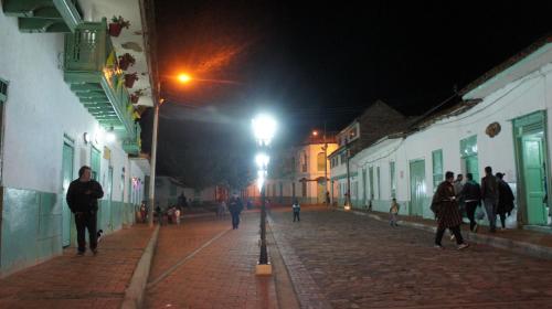 a group of people walking down a street at night at Hotel Museo la Posada del Molino in El Cocuy
