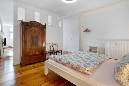 a bedroom with a bed and a wooden cabinet at Alte Seifensiederei 3 in Stralsund