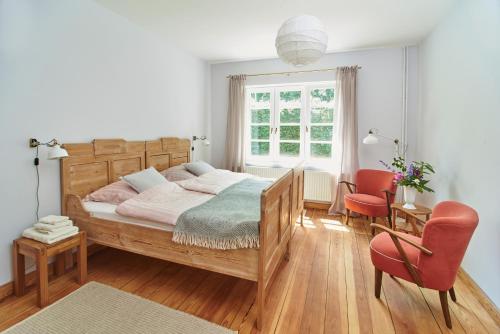 a bedroom with a wooden bed and a red chair at Große Atelierwohnung Barrierefrei in Meezen