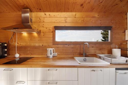 a kitchen with a counter with a sink and a window at Casa da Lagoa Pateira in Fermentelos
