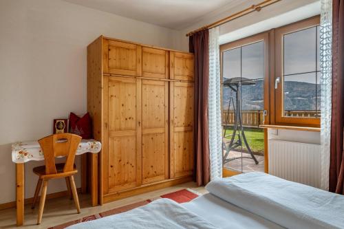 a bedroom with a bed and a desk and a window at Malsötscherhof Apt A in Villandro