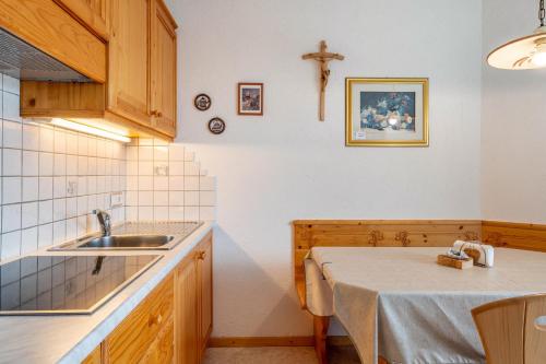 a kitchen with a sink and a cross on the wall at Malsötscherhof Apt A in Villandro