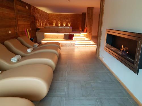 a living room with couches and a fireplace at Aqua Apartments Spa Housemuhlbach in Sappada