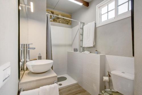 a white bathroom with a sink and a toilet at Estudio Calima in Arico