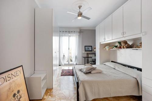 a white bedroom with a bed and a ceiling fan at Casa Rose di Mare in Albenga