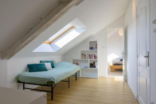 a bedroom with a bed and a skylight at Le Gite De Luca in Husseren-les-Châteaux
