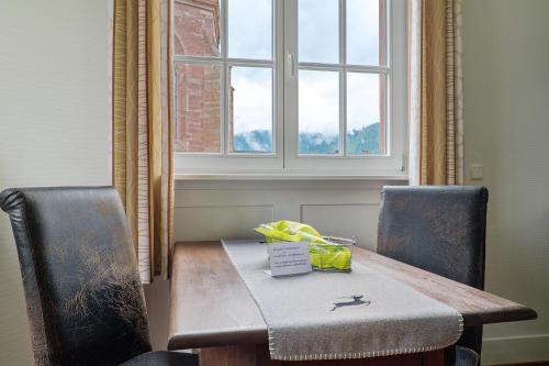 a table and two chairs with a table and a window at Landhaus Christophorus in Forbach