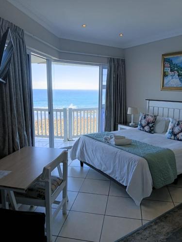 a bedroom with a bed and a view of the ocean at The White House Guesthouse in East London