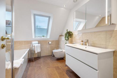 a bathroom with a sink and a tub and a toilet at Ferienwohnung Oertzheide in Hermannsburg