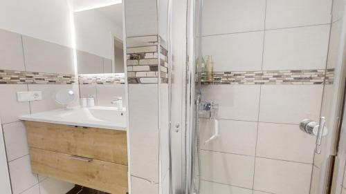 a white bathroom with a sink and a shower at Urlaub auf dem Land in Triepkendorf