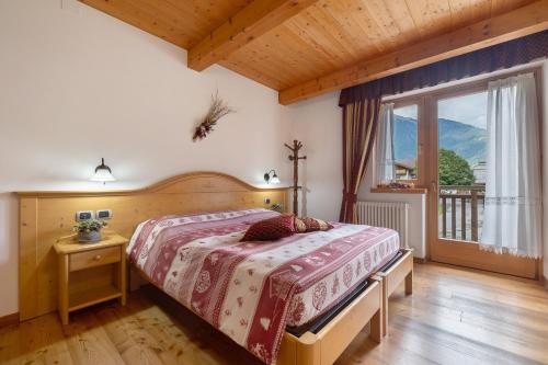 a bedroom with a bed and a large window at Agritur Maso Pan in Caderzone Terme