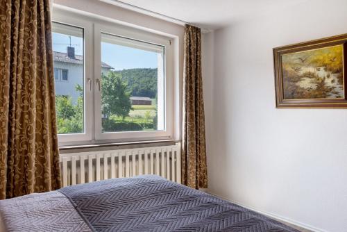 a bedroom with a bed and a window at Haus Lerchenweg B in Bad Wildungen