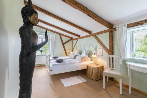 a bedroom with a bed with a statue in it at Ferienwohnung alter Heuboden in Steinbergkirche