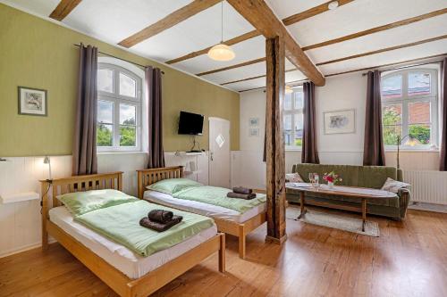 a bedroom with two beds and a couch and a table at Starenhof Ferienhaus in Schlagsdorf