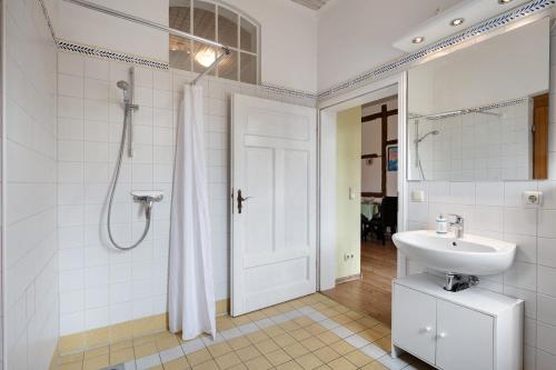 a white bathroom with a sink and a shower at Starenhof Ferienhaus in Schlagsdorf