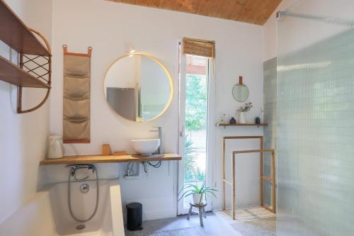 a bathroom with a sink and a mirror and a shower at Maison Vacances Gaetan in Binic