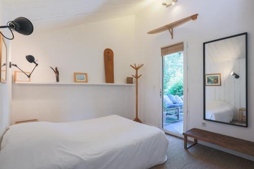 a bedroom with a white bed and a mirror at Maison Vacances Gaetan in Binic
