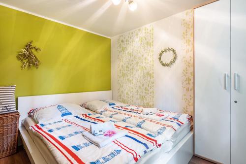 a bed in a room with a green wall at Bungalow Passat - Bgl 5 in Dranske
