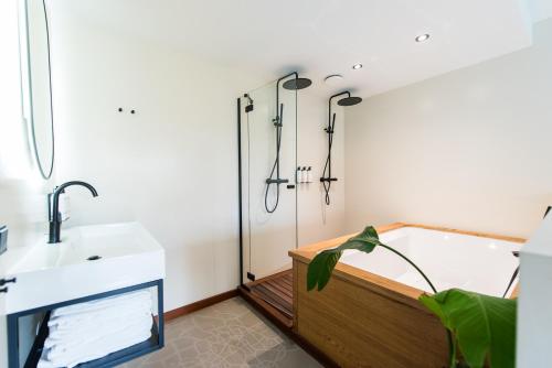 a bathroom with a bath tub and a sink at Van Heeckeren City Centre Jacuzzi Lofts in Nes