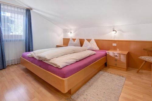a bedroom with a large bed with a purple mattress at Haus Peer Burgeis in Malles Venosta