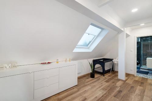 a kitchen with white cabinets and a window at Le Quartier Blackforest-Straßburg in Willstätt