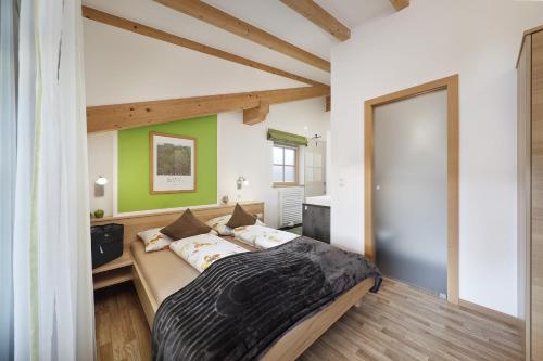 a bedroom with a large bed with green walls at Feldhof Apartment Apfeloase in Caines