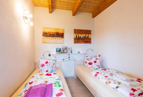 two beds in a room with wooden ceilings at Teufelsmauer-Blick in Thale