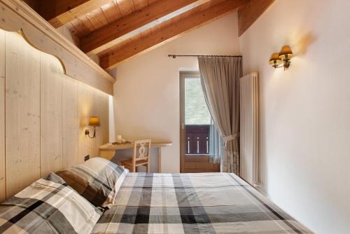 a bedroom with a bed and a window at Chalet La Fiamma in Santa Caterina Valfurva