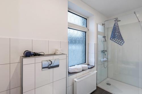 a white bathroom with a shower and a window at Nostalgie Apartment in Kerken