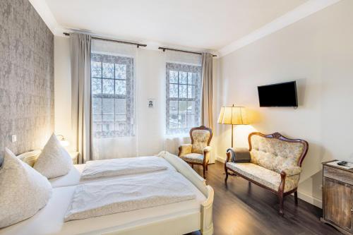 a bedroom with a bed and two chairs at Nostalgie Apartment in Kerken