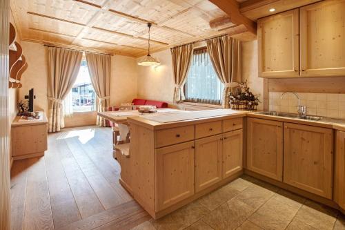 a large kitchen with wooden cabinets and a large island at Chalet La Fiamma in Santa Caterina Valfurva