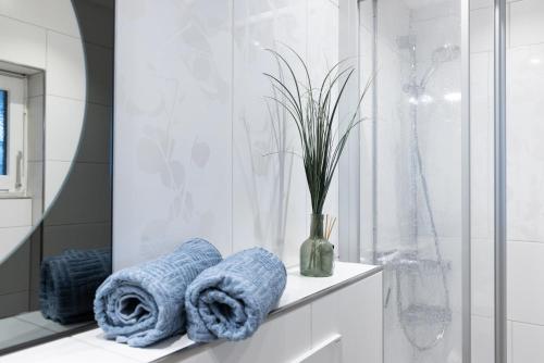 a bathroom with towels and a vase with a plant at Höri-Nest Abendsonne-Appartement in Gaienhofen