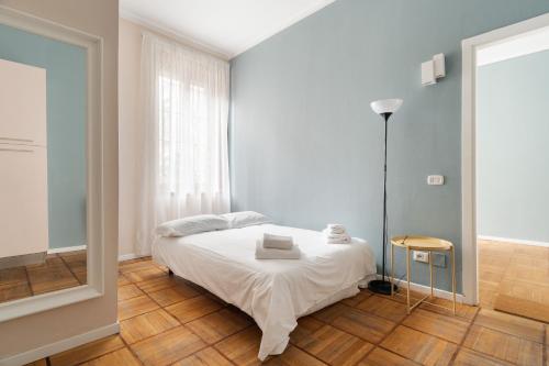 a bedroom with a white bed and a mirror at GuestHost - Chic Flat Steps from Duomo in Milan
