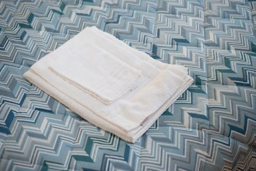 a white towel laying on top of a bed at Podere San Biagio in Capalbio