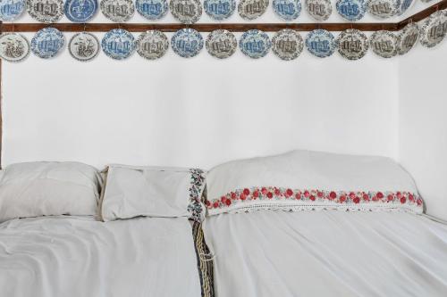 a white bed with blue and white curtains and pillows at Villa Houvarda in Karpathos