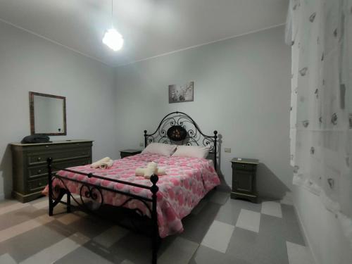 a bedroom with a bed and a dresser and a mirror at Villetta Roby in Marina di Modica