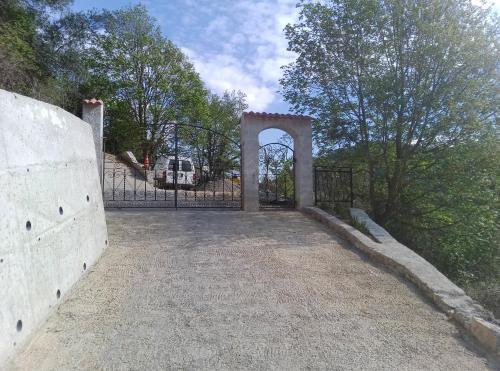 an entrance to a gate in a field with trees at Magnifique roulotte in Sospel