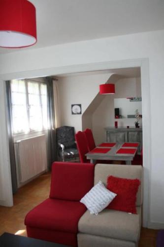a living room with a couch and red chairs at Le Goéland in Sarzeau