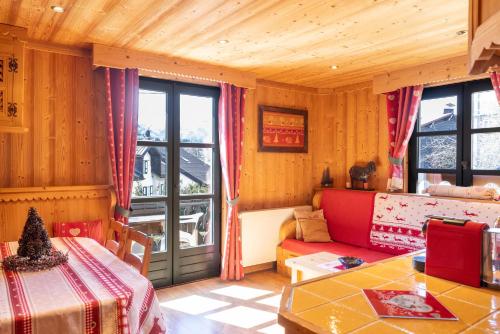 a living room with a couch and a table at Appartement les 4 As in Megève