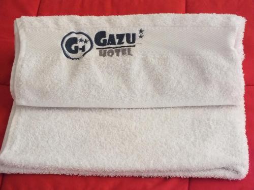 a towel with the gazu hotel logo on it at Hostal Gazu in Chiclayo