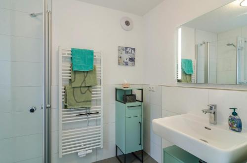 a white bathroom with a sink and a shower at Turmgarten in Überlingen