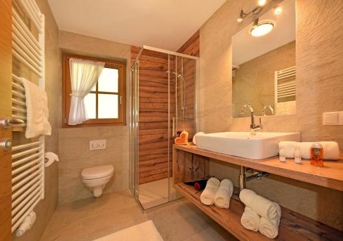 a bathroom with a sink and a toilet and a mirror at Tratterhof Apt Eidechsspitze in Vandoies
