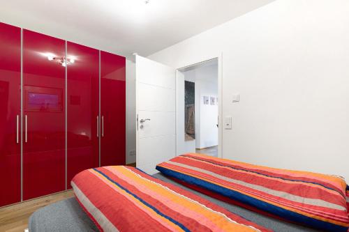 a bedroom with two beds and red cabinets at Ferienwohnung Kleeblatt in Herbolzheim