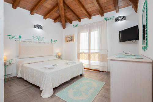 a bedroom with a bed and a flat screen tv at Appartamento Zeus in Tanaunella