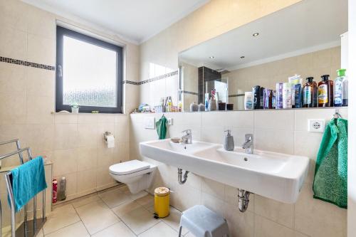 a bathroom with a sink and a toilet and a mirror at Wohnung mit 3 Schlafzimmern in Solingen