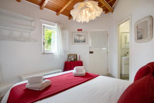 a bedroom with a large bed with two towels on it at Páteo da Várzea 3 in Colares