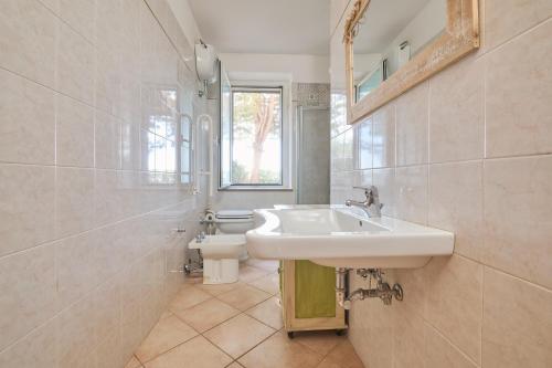 a bathroom with a sink and a toilet at Verde - Euroappartamenti in San Vincenzo